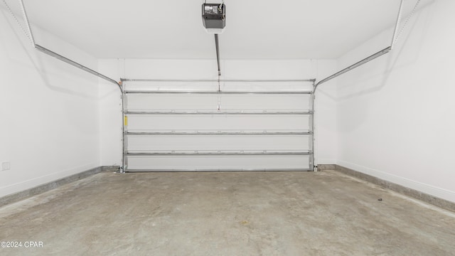 garage with baseboards and a garage door opener