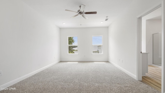 carpeted empty room featuring baseboards and a ceiling fan