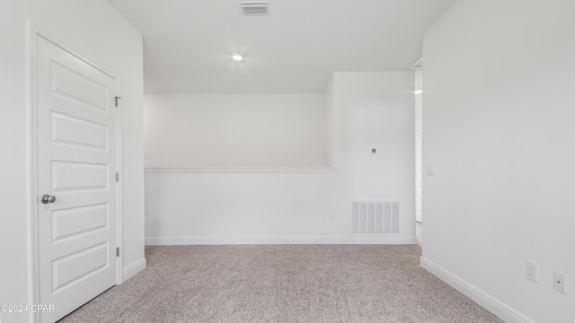 carpeted spare room featuring visible vents and baseboards