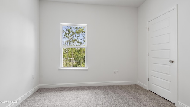 unfurnished room with baseboards and carpet flooring