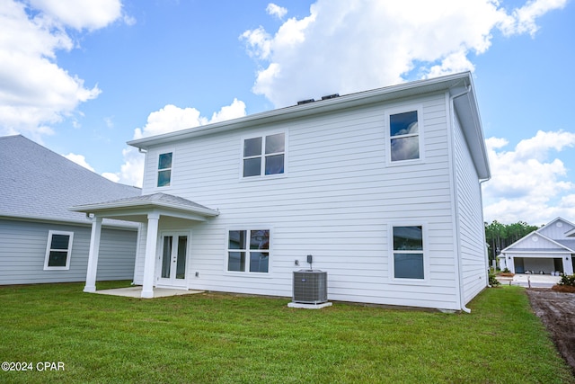 back of property with a lawn, a patio area, french doors, and cooling unit