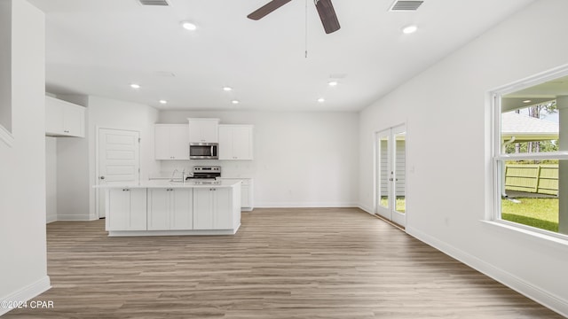 kitchen featuring stainless steel appliances, baseboards, plenty of natural light, and light wood-type flooring
