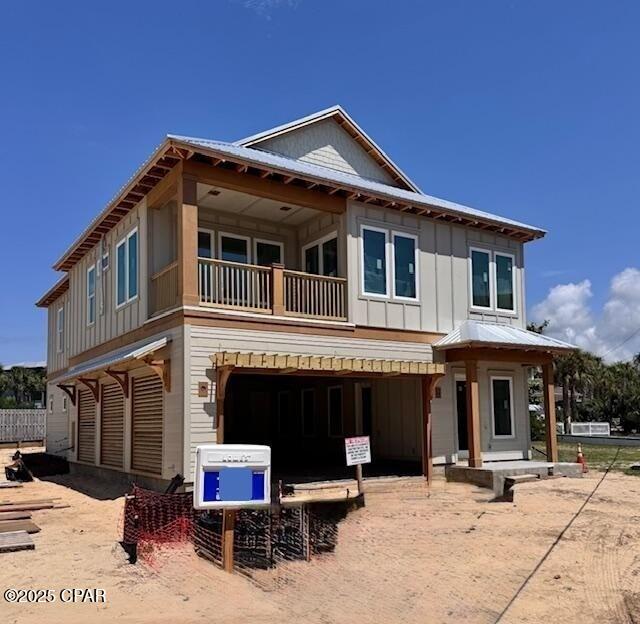 244 Sands St, Panama City Beach, FL 32413 - view of front of property featuring a balcony, board and batten siding, a garage, and fence