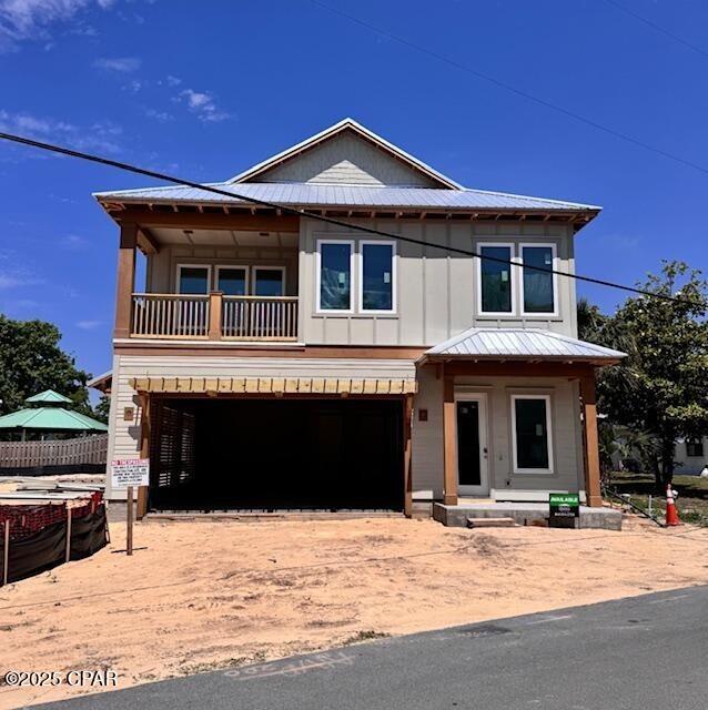 244 Sands St, Panama City Beach, FL 32413 - view of front facade featuring a balcony, an attached garage, metal roof, and board and batten siding