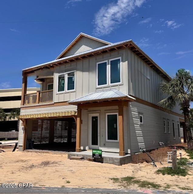 244 Sands St, Panama City Beach, FL 32413 - view of front of house with board and batten siding, a balcony, and metal roof