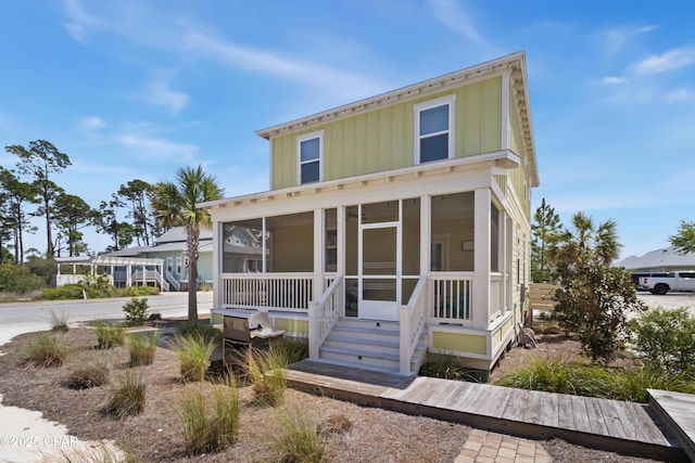 view of front of property featuring board and batten siding and a sunroom