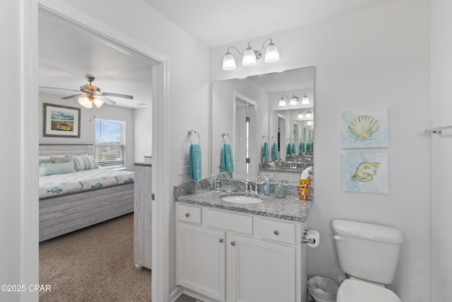 bathroom featuring toilet, ceiling fan, vanity, and connected bathroom