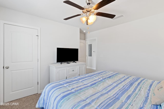 bedroom featuring visible vents, ceiling fan, light colored carpet, and electric panel