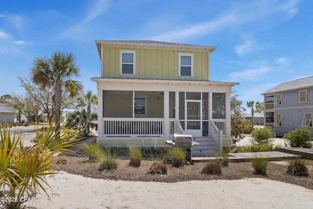 view of front of home with board and batten siding and a sunroom