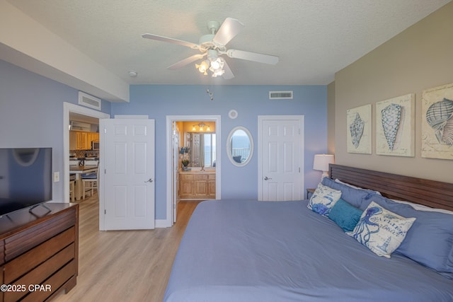 17643 Front Beach Rd Unit 1805, Panama City Beach, FL 32413 - bedroom featuring light wood finished floors, a textured ceiling, ensuite bath, and a ceiling fan