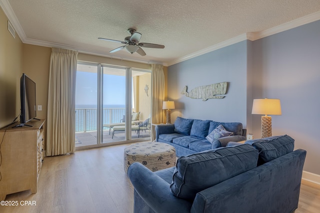 17643 Front Beach Rd Unit 1805, Panama City Beach, FL 32413 - living room with light wood-type flooring, a ceiling fan, a textured ceiling, and crown molding