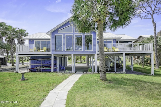 7124 Leeward St, Port St Joe, FL 32456 - back of house featuring a wooden deck, stairs, a carport, a lawn, and metal roof