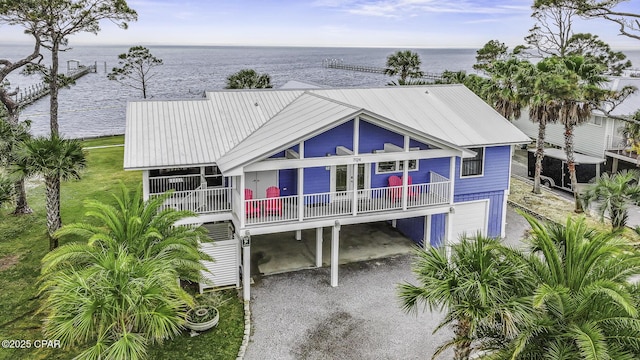 7124 Leeward St, Port St Joe, FL 32456 - view of front of home featuring a carport, a water view, french doors, and dirt driveway