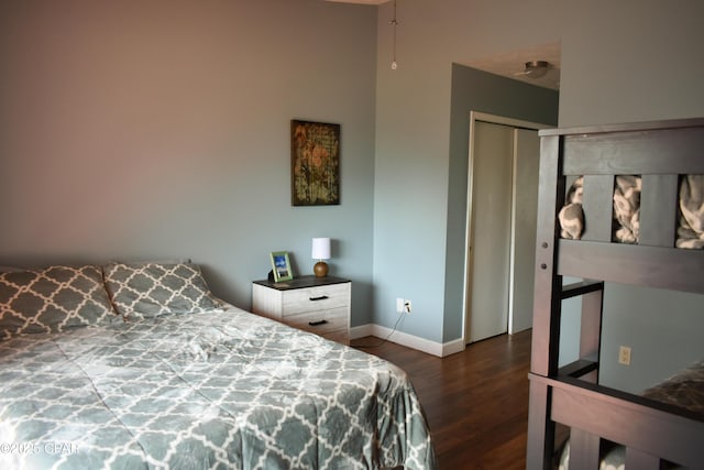 bedroom featuring wood finished floors, a closet, and baseboards