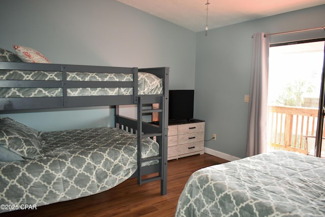 bedroom with lofted ceiling, baseboards, and dark wood-style floors