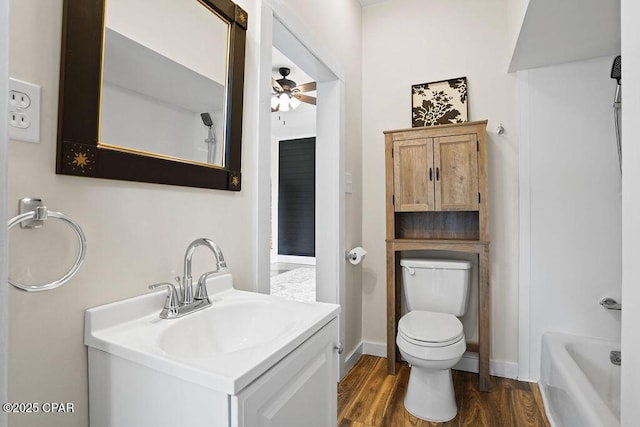full bath featuring wood finished floors, vanity, toilet, ceiling fan, and a bath