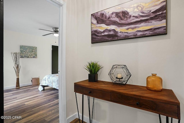 hallway featuring baseboards and wood finished floors