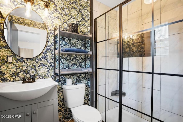 full bathroom featuring wallpapered walls, a stall shower, toilet, and vanity