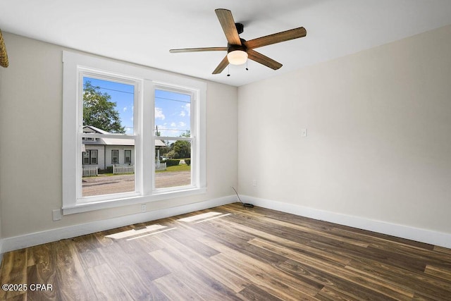empty room featuring baseboards, wood finished floors, and a ceiling fan