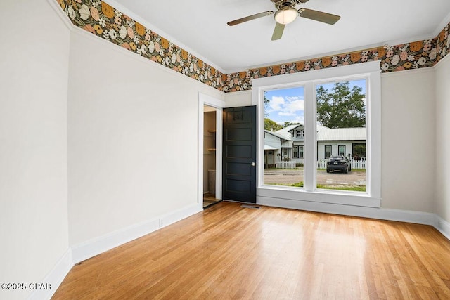 empty room featuring baseboards, visible vents, wood finished floors, and a ceiling fan