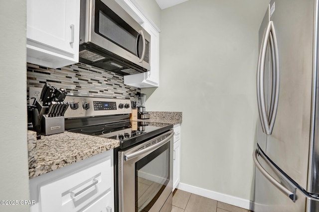 kitchen featuring light tile patterned floors, tasteful backsplash, light stone countertops, and stainless steel appliances