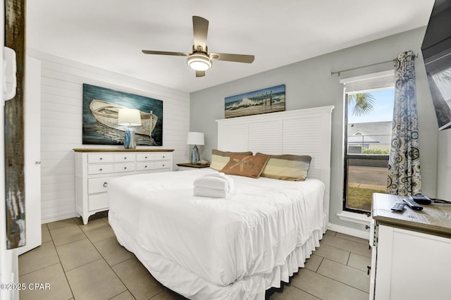 bedroom with light tile patterned flooring, a ceiling fan, and baseboards