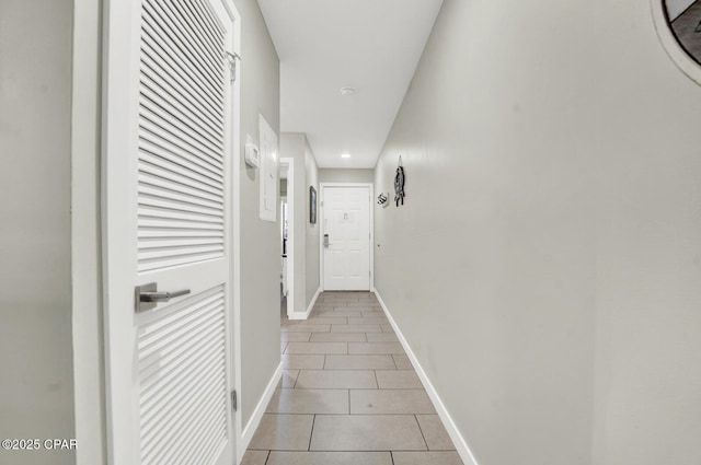 corridor with baseboards and light tile patterned floors