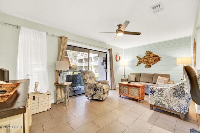 living area featuring light tile patterned floors, a ceiling fan, and visible vents