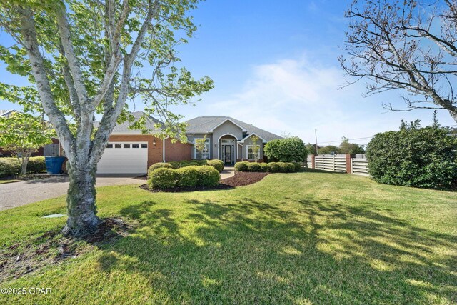 2015 Tupelo Ct, Panama City, FL 32405 - view of front facade with a front yard, fence, a garage, and concrete driveway