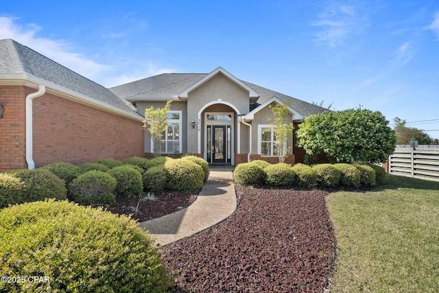 2015 Tupelo Ct, Panama City, FL 32405 - view of front of home featuring a front yard, fence, brick siding, french doors, and a shingled roof