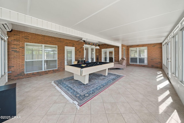 2015 Tupelo Ct, Panama City, FL 32405 - recreation room with brick wall, plenty of natural light, a wall unit AC, and light tile patterned flooring
