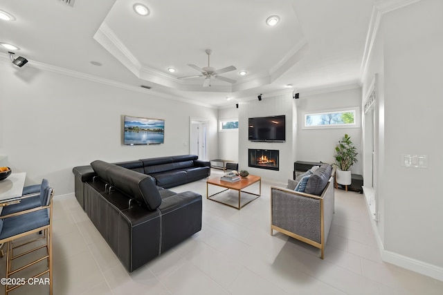 2015 Tupelo Ct, Panama City, FL 32405 - living room featuring crown molding, a large fireplace, a raised ceiling, and a ceiling fan