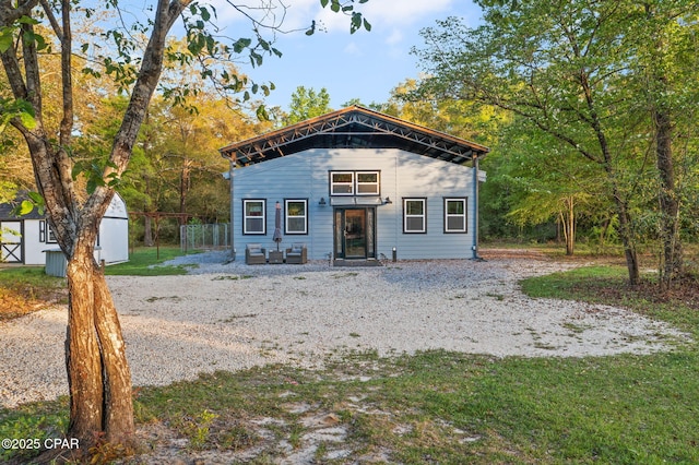 view of front facade featuring fence and an outdoor structure