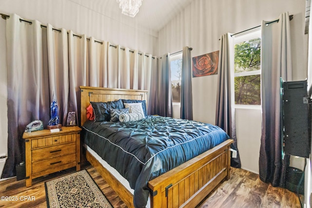bedroom with an inviting chandelier and wood finished floors