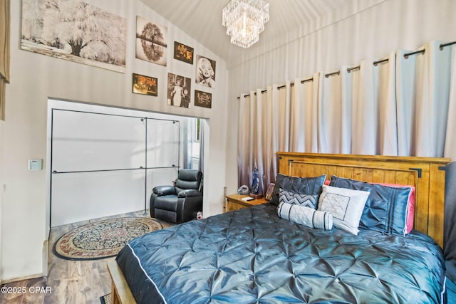 bedroom with wood finished floors and a notable chandelier