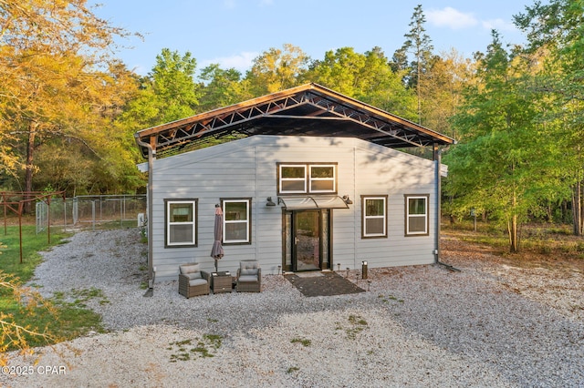 view of outbuilding featuring fence, an outdoor living space, and a carport