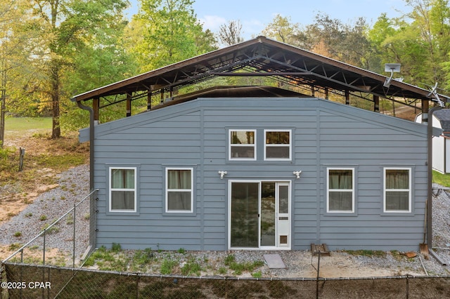 rear view of house featuring fence