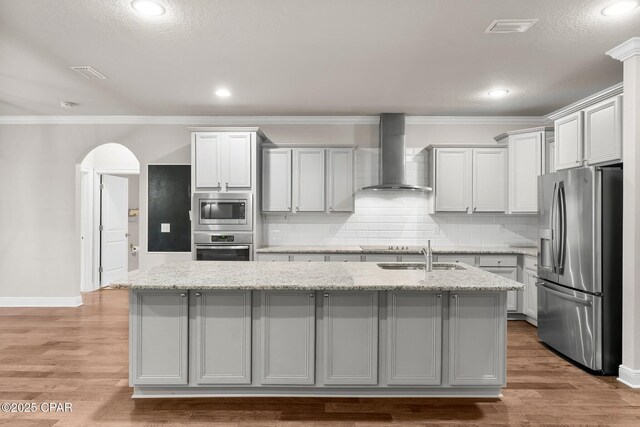 31 Viper Rd, Santa Rosa Beach, FL 32459 - kitchen with wall chimney exhaust hood, visible vents, appliances with stainless steel finishes, a sink, and a center island with sink