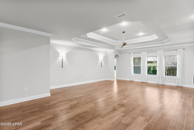 31 Viper Rd, Santa Rosa Beach, FL 32459 - unfurnished living room featuring light wood-style floors, arched walkways, ornamental molding, visible vents, and a raised ceiling