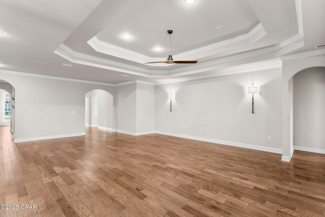 31 Viper Rd, Santa Rosa Beach, FL 32459 - unfurnished living room with arched walkways, ornamental molding, ceiling fan, a tray ceiling, and light wood finished floors