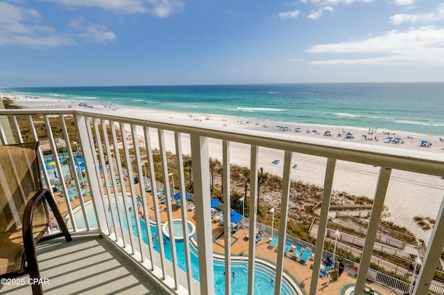 balcony with a water view and a view of the beach