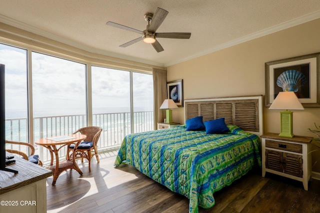 bedroom with access to exterior, multiple windows, hardwood / wood-style flooring, and a water view