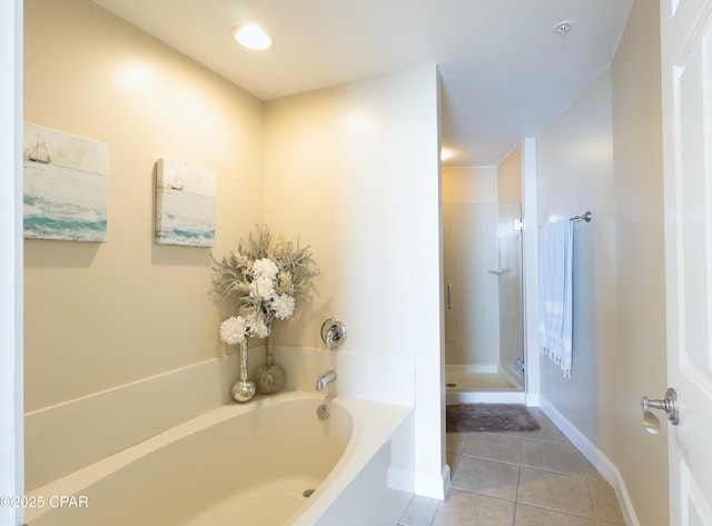 full bath with a bath, a shower stall, tile patterned flooring, and baseboards