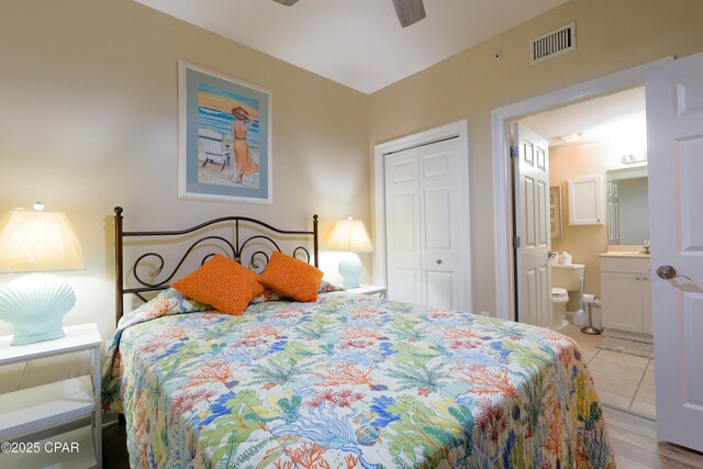 bedroom with ensuite bath, visible vents, a closet, and ceiling fan