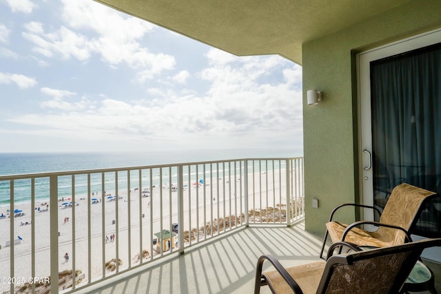 balcony featuring a beach view and a water view