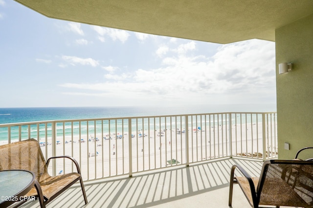 balcony featuring a beach view and a water view