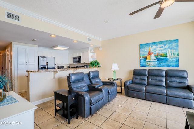 living room with crown molding, light tile patterned floors, a ceiling fan, and visible vents