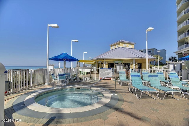 view of swimming pool with a gazebo, fence, and a hot tub