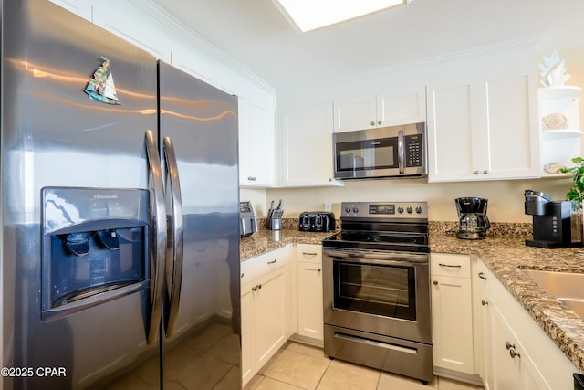 kitchen featuring light stone counters, light tile patterned floors, white cabinetry, and stainless steel appliances