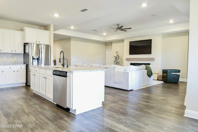 kitchen with a sink, ceiling fan, stainless steel appliances, and white cabinets